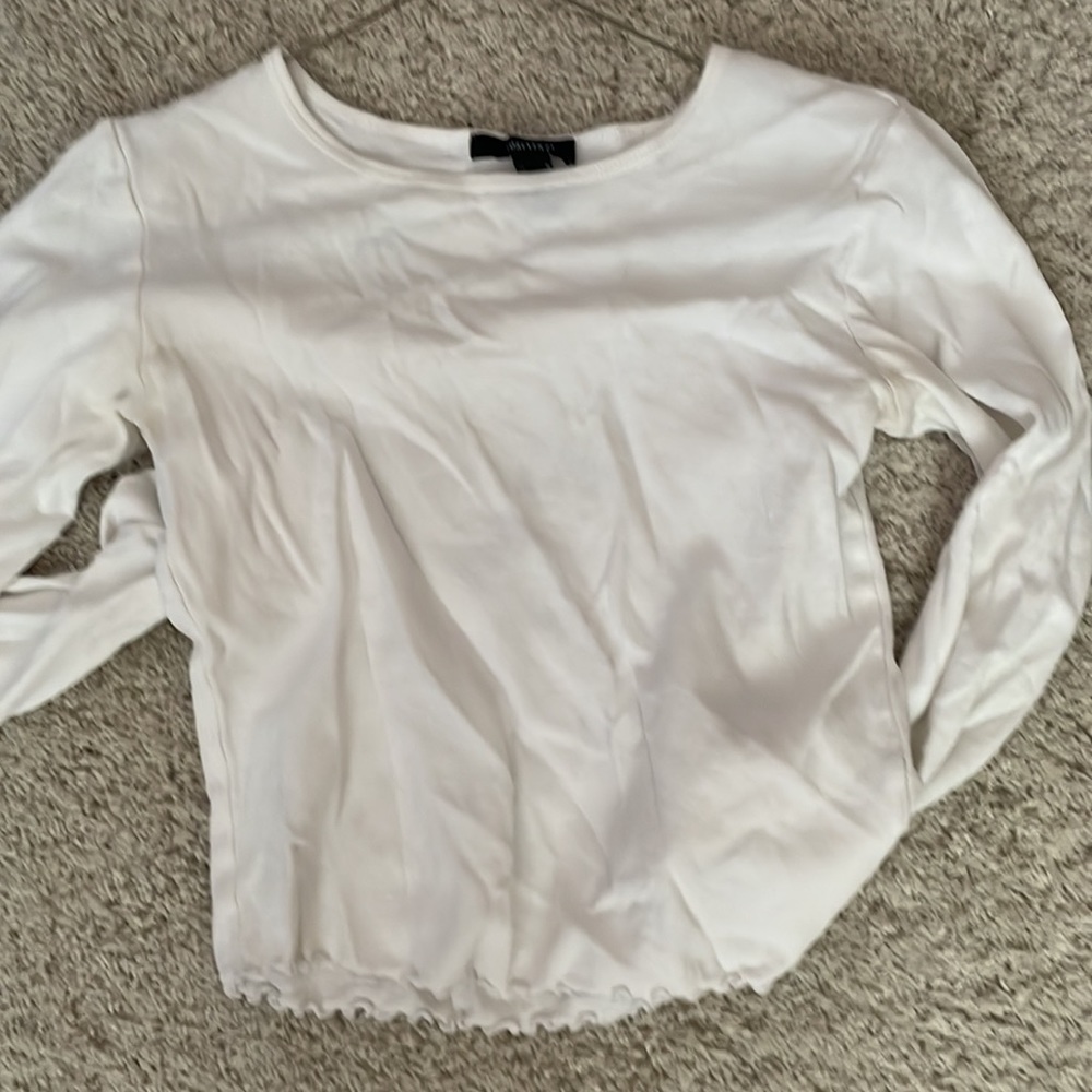A white long sleeve with ruffles in the bottom